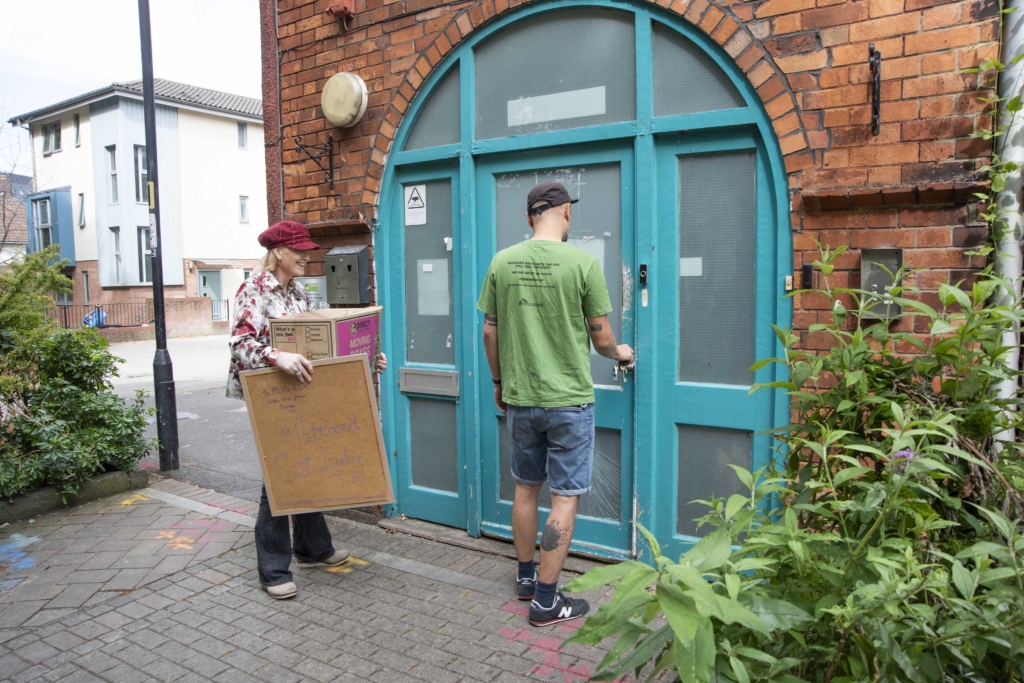 A photo of a companion arriving at Emmaus, and the door being opened by a support worker