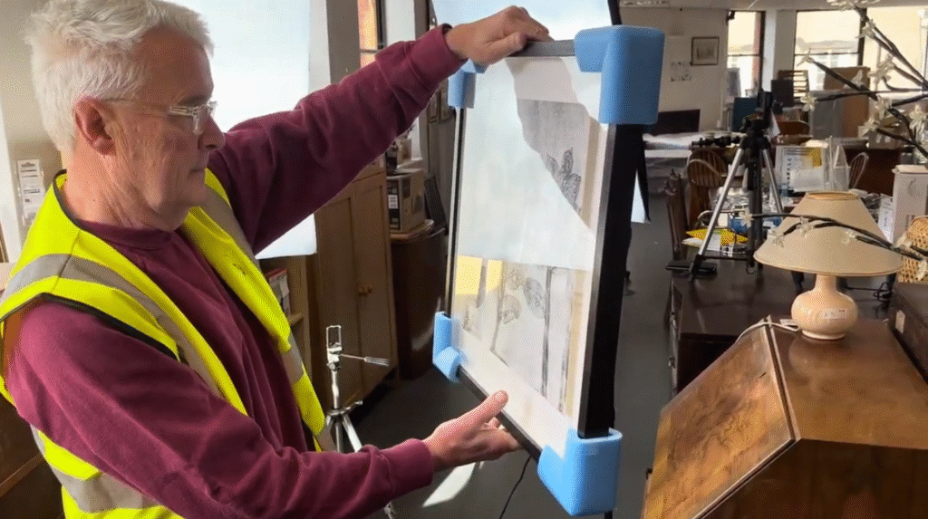 Art volunteer organising art kindly donated by local artists to Emmaus Bristol