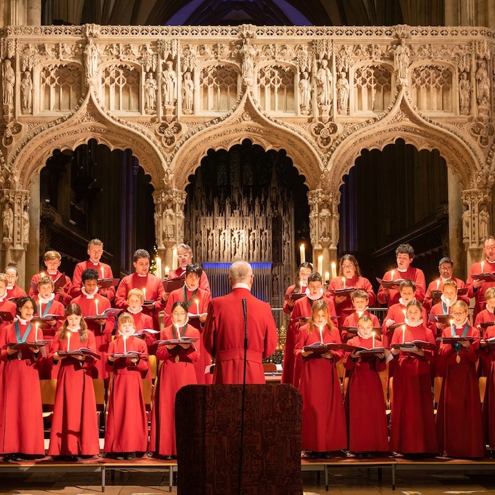 A photo of the choir singing, all dressed in red, inside beautiful Bristol Cathedral