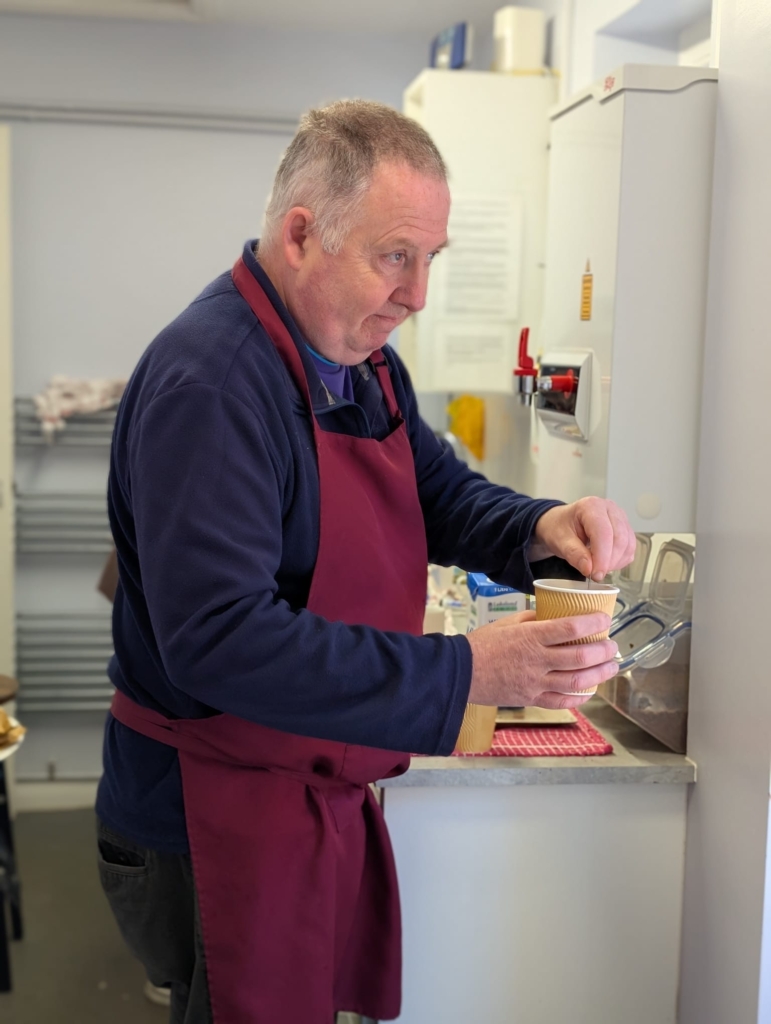 A photo of companion Nigel cooking at the food bank